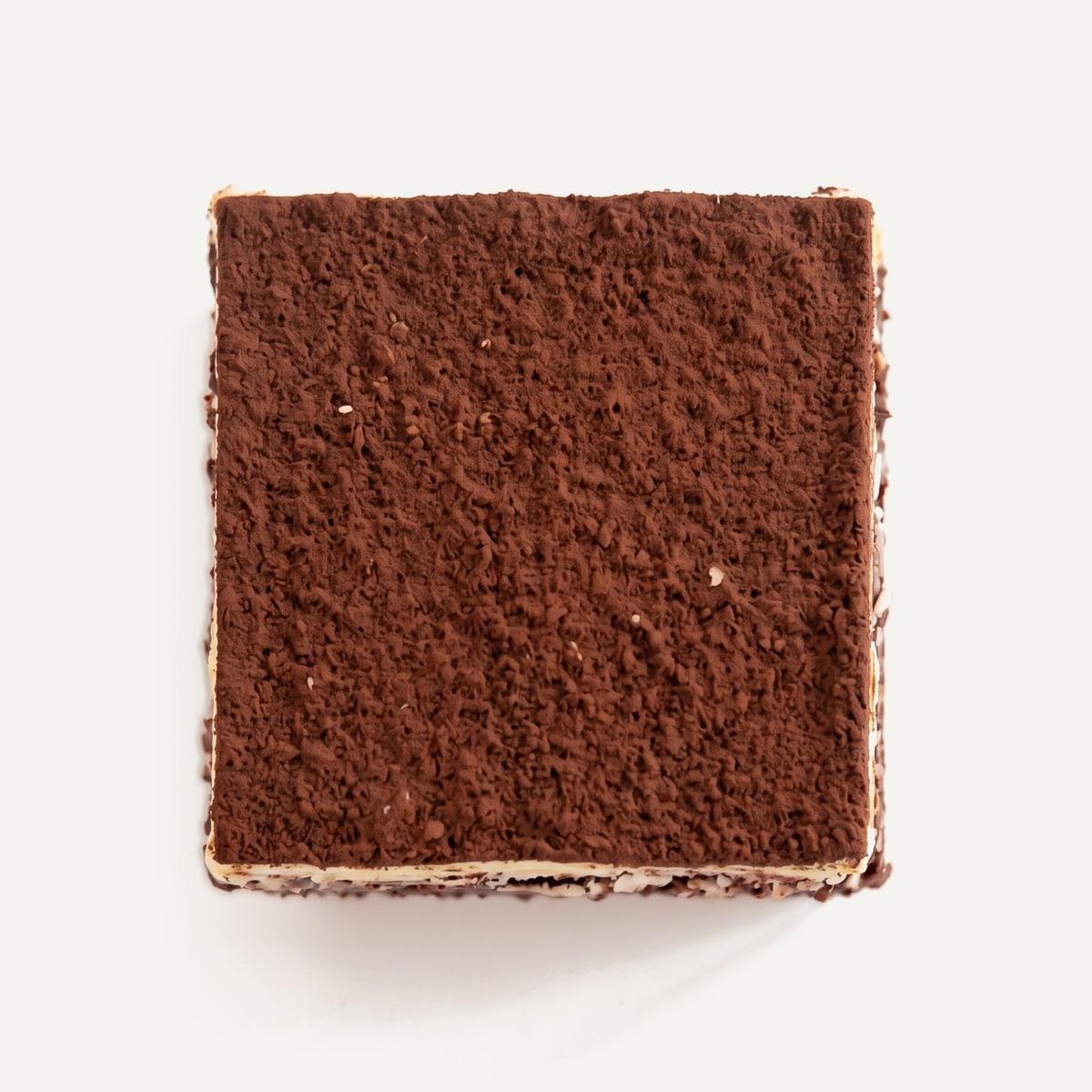 A tiramisu brownie from above: a matte cocoa top over a thin pale layer