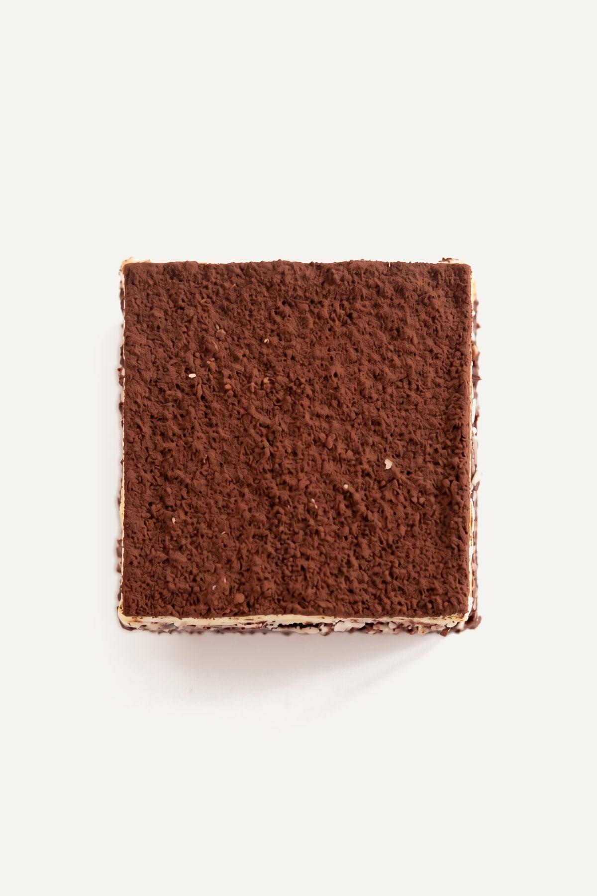 A tiramisu brownie from above: a matte cocoa top over a thin pale layer